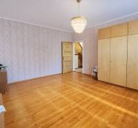 Interior of a family house with a wooden decor floor, chandelier, and built-in wardrobe.