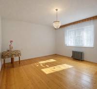 A spacious room in a family house with a wooden decor floor and an elegant chandelier.