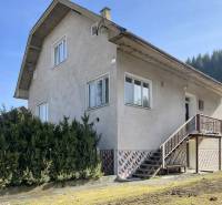 A family house in Terchová with large windows, a staircase, and a well-maintained front garden.