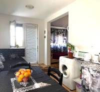 A kitchen in a studio apartment with a washing machine, table, and decor on the table.