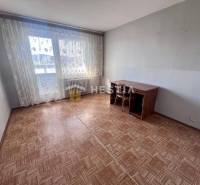 A room in a 3-room apartment with a wooden decor floor and large windows.