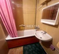 Bathroom with a sink and a bathtub in a 3-room apartment, a pink curtain adds a striking element.