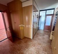 Hallway of a 3-room apartment with wooden decor, built-in wardrobes, and glass doors.