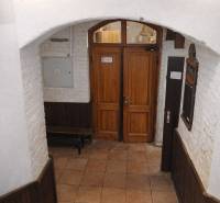 Entrance door in commercial premises with a brick wall and tiled floor.