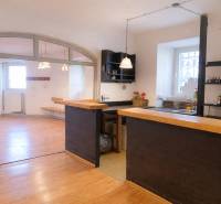 Commercial space with a bar counter and a wooden decor floor. Bright room with windows.