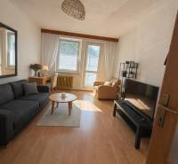 Living room in a three-room apartment with a wooden decor floor and comfortable furniture.