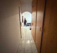 A narrow hallway with tiled flooring and built-in wardrobes leading to the living area of a 3-room apartment.