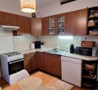 A kitchen in a 4-room apartment with a wooden decor floor, including equipment.