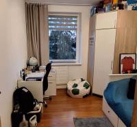 Children's room in a 4-room apartment with a desk, bed, and floor with a wooden decor.