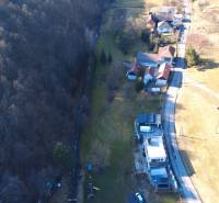 An aerial view in Župkov shows buildings and a forest next to recreational grounds.