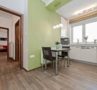 A kitchen in a 2-room apartment with a dining area and a wooden decor floor.