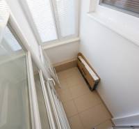 A balcony with folding doors and tiles in a 2-room apartment.