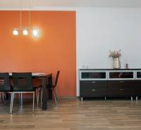 A kitchen with a dining table and a sideboard in a 2-room apartment with a wooden decor floor.