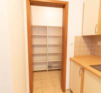 A kitchen in a 2-room apartment with shelves and tiles, cabinets with a wooden decor.