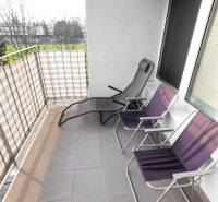 Balcony of a 2-room apartment with metal railing and three folding chairs on Hrachova Street, Bratislava - Ružinov.
