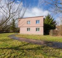 A two-story family house in Tŕstie surrounded by a garden with a lawn and trees.