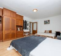 A room in a family house with a large wooden wardrobe and two beds.