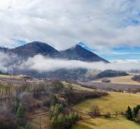 A landscape in Tŕstie with hills in the background and fog over the pasture.