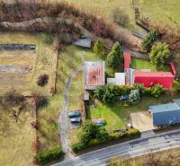 A family house in Tŕstie surrounded by a garden and trees, stands by the road.