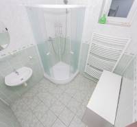 A bathroom in a family house with a modern shower and a round mirror.