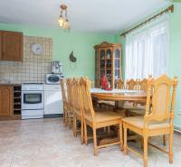 A kitchen in a family house with wooden furniture, ceramic tiles, and appliances.