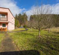 A family house in Tŕstie with a balcony and trees in a spacious garden.