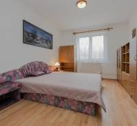 Bedroom in a family house with wood-patterned flooring, a double bed, and furniture.
