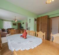 Dining room in a family house with a spacious table and green walls.