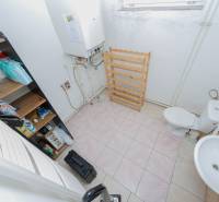 Bathroom with toilet in a family house, includes a boiler and storage spaces.