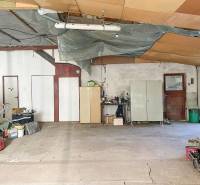 The interior of a family house with a spacious area, stored items, and a cement floor.
