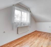A room in a family house with a window and a wooden decor floor.