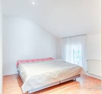 Bedroom in a family house with a large bed and a floor with a wood decor.