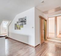 Interior of a family house with stairs, wooden floor decor, and a painting on the wall.