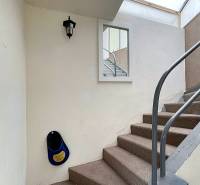 A staircase in a family house with white walls and a metal railing.