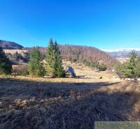 Agricultural and forest lands in Hronec, surrounded by hills and coniferous trees.