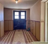 Entrance hall of a family house with a colorful floor and wooden paneling on the walls.