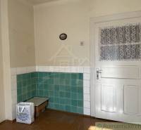 Interior of a family house with white doors and green and white tiles on the walls.
