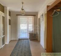 Interior of a family house with a wood-patterned floor, curtain, and carpet.