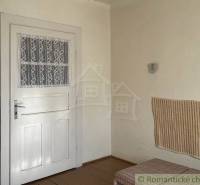 Interior of a family house with white doors, paneling, and flooring with a wooden decor.