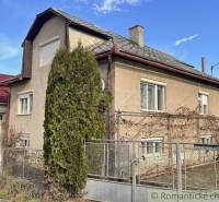 A family house in Bretka with a sloped roof, in front of the house is a tall conifer.
