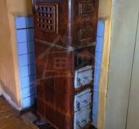 Tiled stove in a family house with a wooden decor floor.