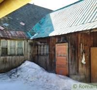A wooden family house in Osturňa with snow-covered ground and a metal roof.