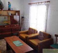 Living room in a family house with older furniture and simple furnishings.