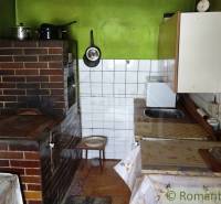 Rustic kitchen with a brick stove and green walls in a family house.