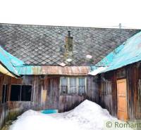 A wooden family house in Osturňa with a snowy yard and a tin roof.