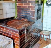 A kitchen in a family house with a traditional brick oven and dishes on the stove.