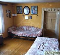 Interior of a family house with wooden flooring, tables, chairs, wall decorations.