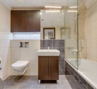 Bathroom with a washing machine, bathtub, and mirror in a 3-room apartment.