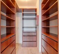 A wardrobe in a 3-room apartment with shelves and a wooden decor floor.