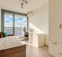 A bright room with a desk, bed, and wardrobe in a 3-room apartment, with a wooden decor floor.